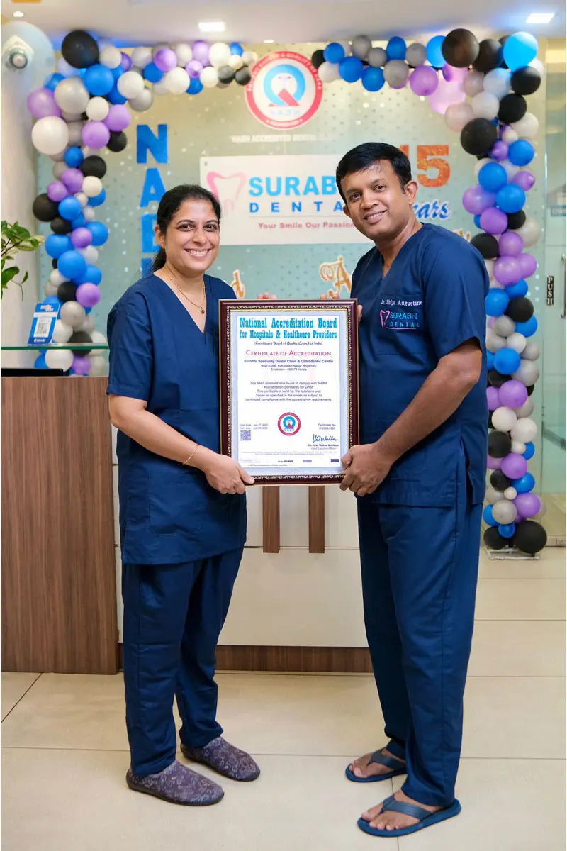 best-dental-clinic-kerala-anniversary-certificate Staff holding a 15-year anniversary certificate at Best Dental Clinic in Angamaly, Kerala.